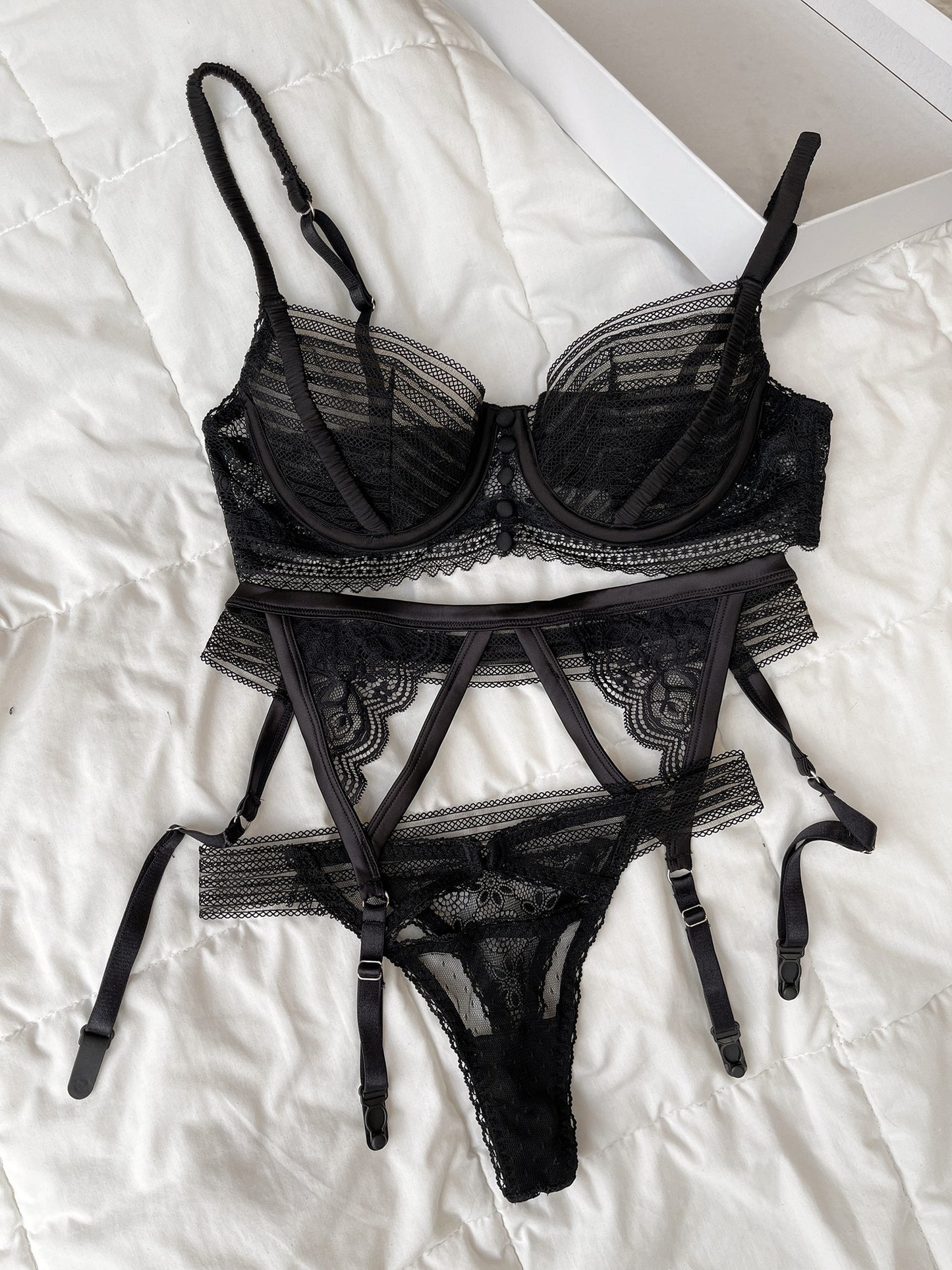 Set nội y ren nữ 3 món màu đen thiết kế No.05 kèm đai eo của thương hiệu Lacy Lingerie flatlay.