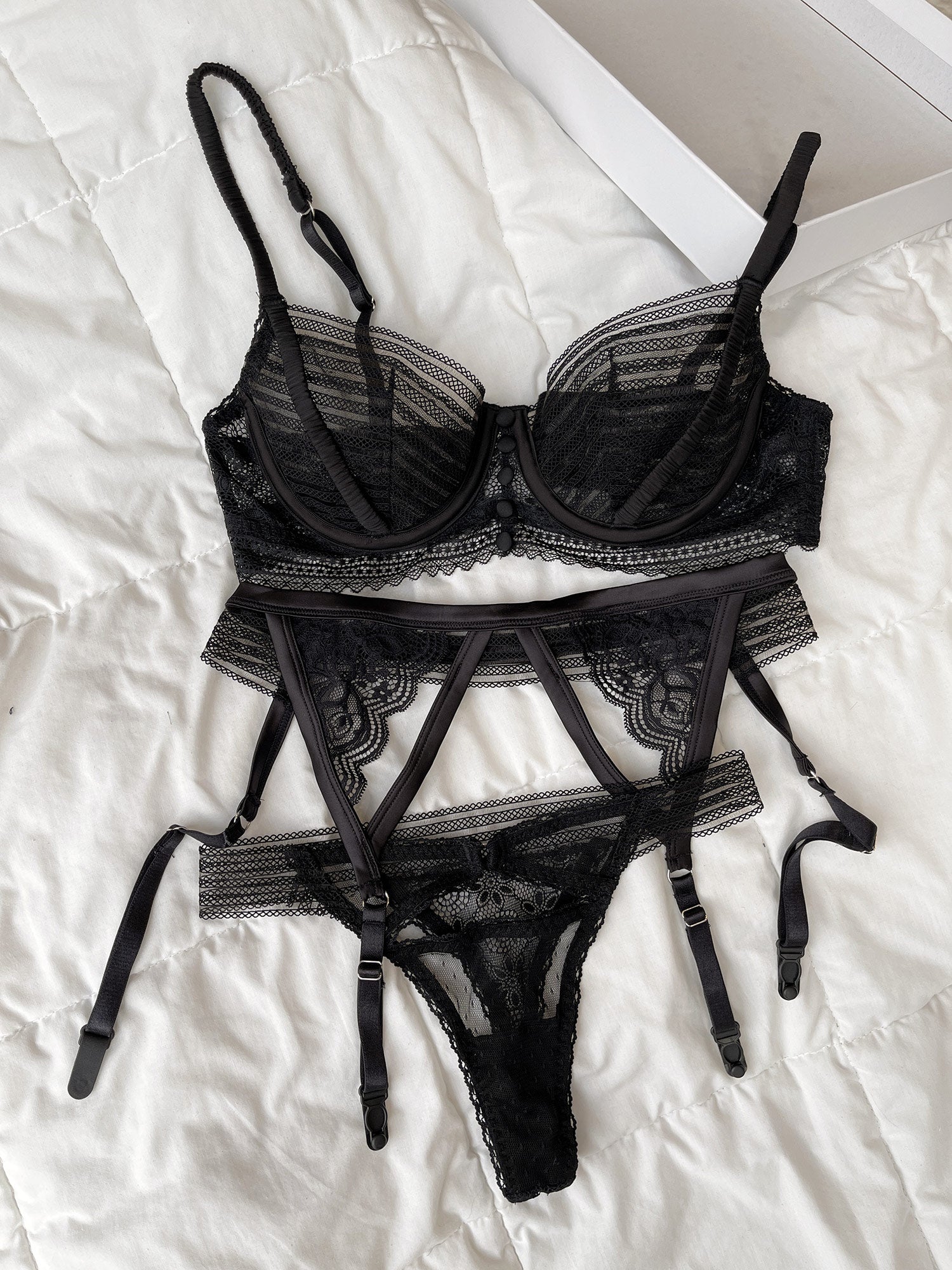 Set nội y ren nữ 3 món màu đen thiết kế No.05 kèm đai eo của thương hiệu Lacy Lingerie flatlay.